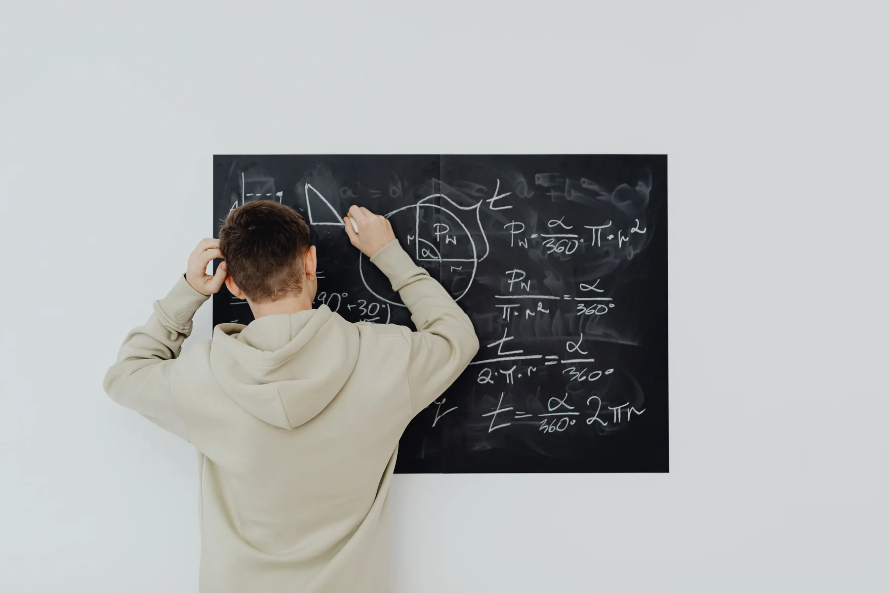 Étudiant révisant une notion quantitative au tableau.